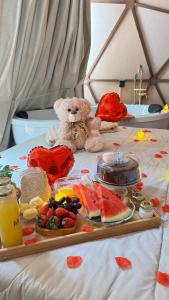 a teddy bear sitting on a bed with a tray of food at Cabana winchesters - Domo in Cascavel