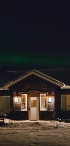 基律纳Riverfront Aurora Chalet的上面有绿色的北极光的房子