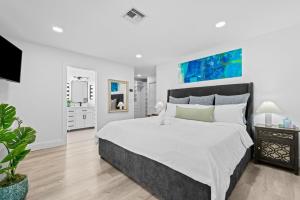 ポンパノビーチにあるWaterfront Villaの大きなベッドとバスルームのある寝室 +30枚の写真