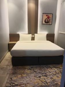 een bed in een kamer met een wit matras bij شقق المتميزين in Al Madinah