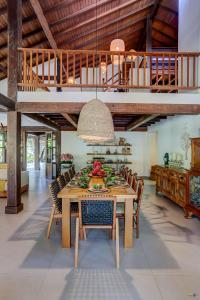 Casa 'Olu'Olu Itacaré في إيتاكاري: غرفة طعام مع طاولة وكراسي خشبية