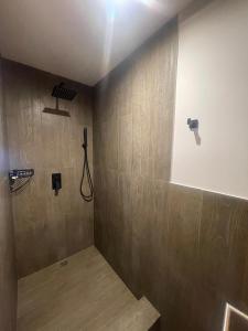 een badkamer met een douche en houten wanden bij Black Hills Caviahue in Caviahue