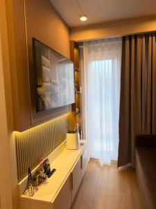 ein Wohnzimmer mit einem Schreibtisch und einem Fenster in der Unterkunft 1413 Home Suites Arezzo Place Davao in Davao City