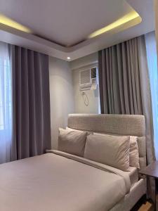 ein Schlafzimmer mit einem Bett und einem Fenster in der Unterkunft 1413 Home Suites Arezzo Place Davao in Davao City