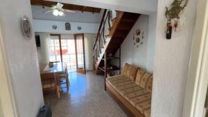 sala de estar con sofá, mesa y escaleras en Edificio Natania, en Villa Gesell 39 fotos más