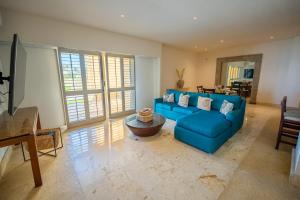 a living room with a blue couch and a table at Hotel Tres Vidas Acapulco in Barra Vieja