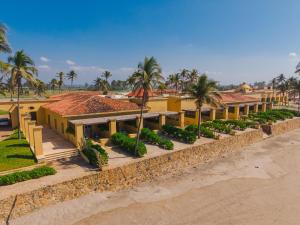 a building on the beach with palm trees at Hotel Tres Vidas Acapulco in Barra Vieja