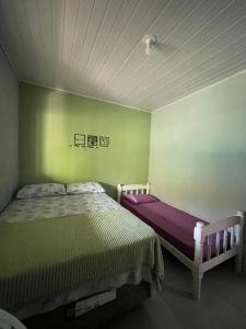 een slaapkamer met 2 bedden in een groene muur bij Casa da Jessica in Paraty +11 foto's