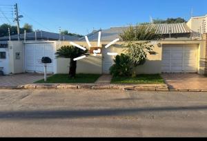 een wit huis met twee witte garagedeuren bij Áurea da Mata in Cuiabá