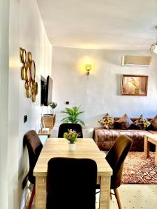een woonkamer met een tafel, stoelen en een bank bij Zyarat Marrakech in Marrakesh