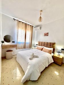 een slaapkamer met een groot wit bed en een raam bij Zyarat Marrakech in Marrakesh