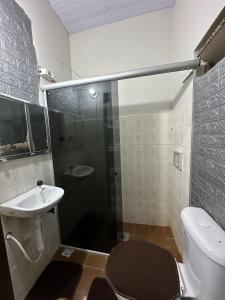 een badkamer met een douche, een toilet en een wastafel bij Zig Zag Hostel in Itacaré