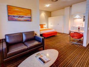 una habitación de hotel con un sofá y una cama en Mantra Charles Hotel, en Launceston 69 fotos más