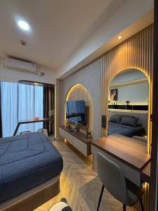 ein Schlafzimmer mit zwei Betten und einem Schreibtisch und einem Spiegel in der Unterkunft Modern Luxury Studio at Pollux by Superstay in Batam Center