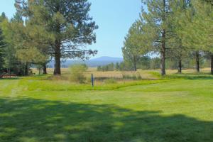 un campo da golf con alberi e un campo verde di Meadow House 58 a Sunriver