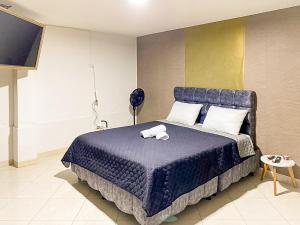 Laureles Coliving House Medellín في ميديلين: غرفة نوم بسرير ازرق عليها حيوان محشو