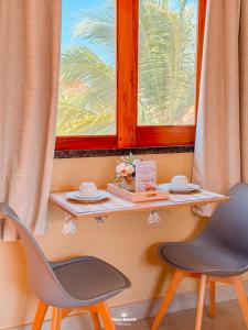 un tavolo e due sedie davanti a una finestra di Zaya Beach Residence a Icaraí