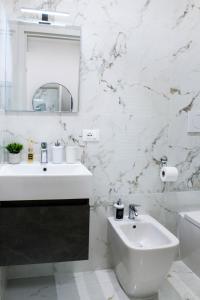 une salle de bains blanche avec un lavabo et un miroir dans l'établissement Golden Nest Padova, à Padoue