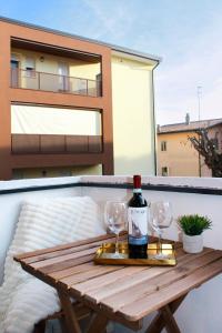 - une table en bois avec 2 verres et une bouteille de vin dans l'établissement Golden Nest Padova, à Padoue