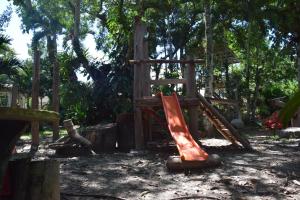 a wooden playground with a slide in a forest at Los Alpes in Ibagué