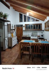 uma cozinha com uma mesa e um fogão forno superior em La Morada del Colibrí em El Tabo