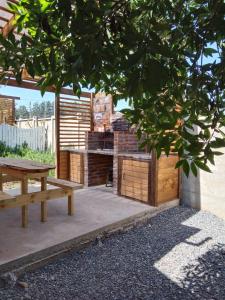 uma mesa de piquenique e um banco num quintal em La Morada del Colibrí em El Tabo