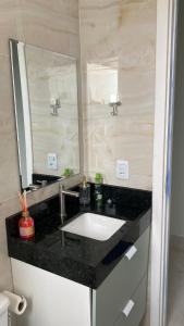 a bathroom with a sink and a large mirror at Apartamento campinas lado Puc 2 in Campinas