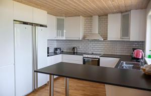 Amazing Home In Bolmsö With Sauna في Bolmsö: مطبخ بخزائن بيضاء وطاولة عمل سوداء