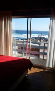 a bedroom with a view of the ocean from a window at El Quisco vista hermosa in El Quisco