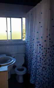 a bathroom with a toilet and a sink and a window at El Quisco vista hermosa in El Quisco