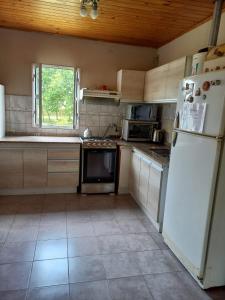a kitchen with white appliances and a white refrigerator at Alquiler Villa Elisa in Villa Elisa
