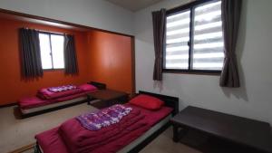 木島平村にある赤い扉ロッジのベッド2台と窓のある寝室