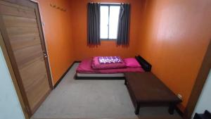 木島平村にある赤い扉ロッジのベッドと窓のある小さな部屋