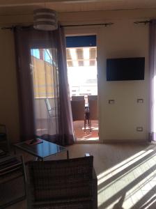 a living room with a table and a sliding glass door at VillaMarì Apartment in Alghero