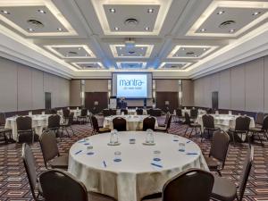 a conference room with tables and chairs and a screen at Mantra on View in Gold Coast