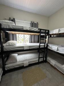 een kamer met 3 stapelbedden en een raam bij Zig Zag Hostel in Itacaré