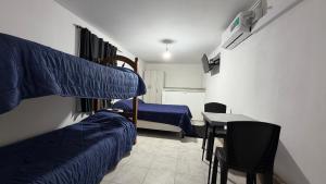 a room with two bunk beds and a table and a desk at brisas del dique in San Fernando del Valle de Catamarca +11 photos