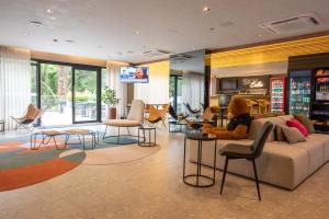 una donna seduta su un divano in soggiorno di Bexpspces Sky Design Alphaville a Aldeia