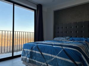 a bedroom with a bed and a large window at Valle Alto in Cayma