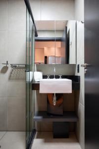 un bagno con lavandino e doccia in vetro di Bexpspces Sky Design Alphaville a Aldeia