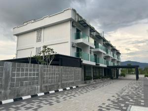 a white building with a fence in front of it at Sena Hotel Langkawi in Kampung Padang Masirat