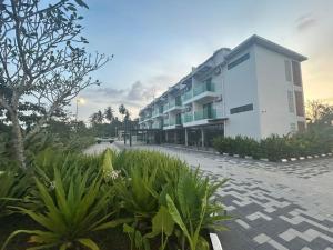a large white building with plants in front of it at Sena Hotel Langkawi in Kampung Padang Masirat