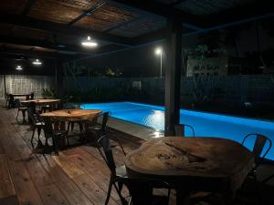 a patio with tables and a swimming pool at night at Sena Hotel Langkawi in Kampung Padang Masirat