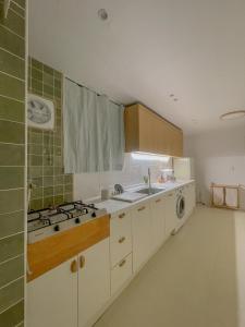a kitchen with a sink and a stove top oven at 10 minutes from Hongdae pure rest in Yeonhui in Samgong
