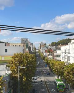 a city street with cars and a green bus at 10 minutes from Hongdae pure rest in Yeonhui in Samgong