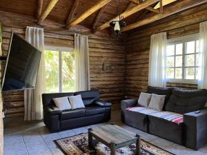 een woonkamer met een bank en een tafel bij Cabana do Lago- Morro da Borússia in Osório