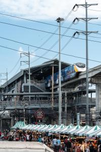 a train on a bridge with a crowd of people at lee hotel lat phrao in Bangkok