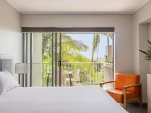 Peppers Salt Resort & Spa في كينغسكليف: غرفة نوم بها سرير وكرسي ونافذة