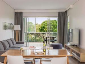 Peppers Salt Resort & Spa في كينغسكليف: غرفة معيشة بها طاولة وأريكة