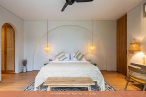 a bedroom with a large bed and a table at Bebas Villas - Uluwatu, Bali in Uluwatu